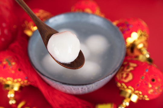 一碗湯圓或元宵和勺子舀一個湯圓