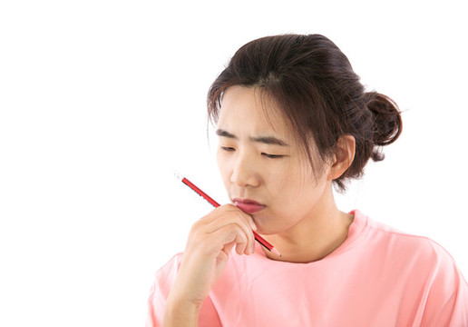 拿著鉛筆陷入沉思的女性