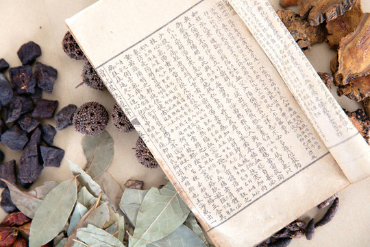 一堆藥材和一本翻開的藥書