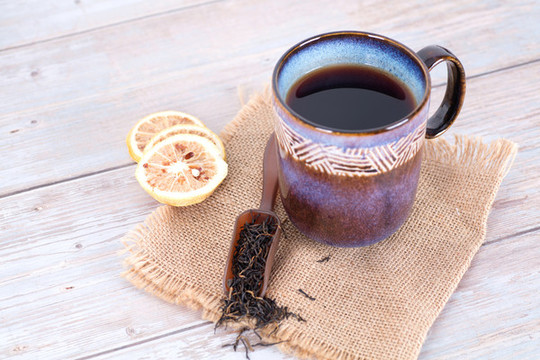 一杯茶水及茶葉和檸檬片