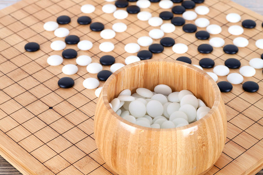 棋盤上散落的棋子和裝滿棋子的木
