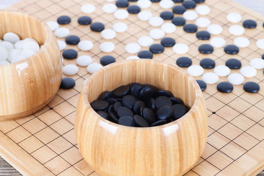 棋盤上散落的棋子和裝滿棋子的木