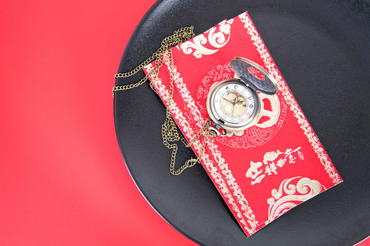 俯視紅背景上的盤子和盤里的紅包