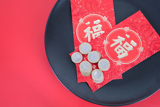 黑色餐盤里的紅包和美元硬幣