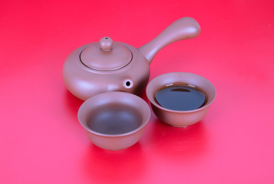 紅背景上的茶壺和茶具