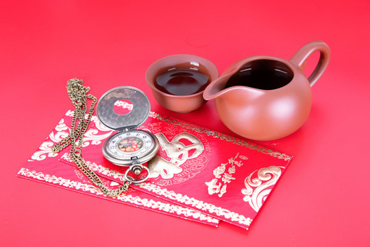 紅背景上的茶具及旁邊的紅包