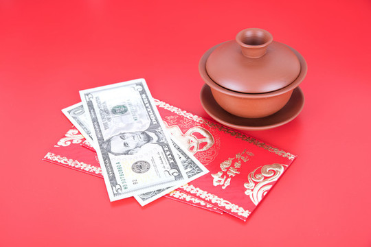 蓋碗茶杯和新年紅包及美元鈔票