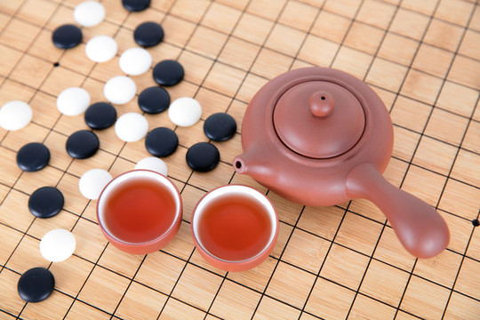 棋盤上的圍棋和喝茶的茶具