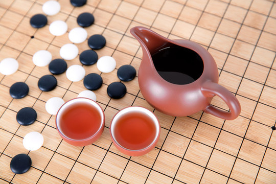 棋盤上的圍棋和喝茶的茶具