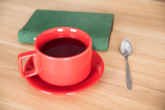 紅茶飲品和筆記本及旁邊的鋼勺