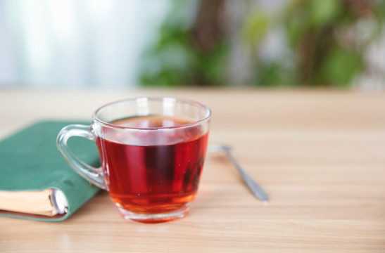 一杯紅茶和一本書及旁邊的勺子