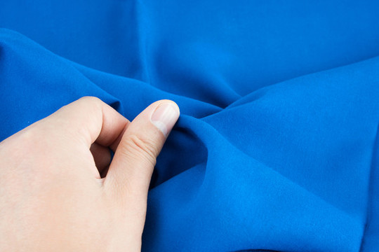 用手檢查新款的衣服布料