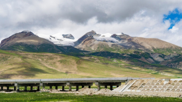 青藏高原雪山與建設(shè)中的高速公路