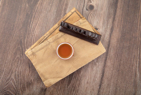 泛黃古書上的一杯茶和鎮(zhèn)紙