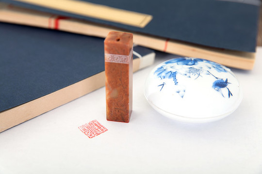 兩本書(shū)旁的一盒印泥和一個(gè)印章