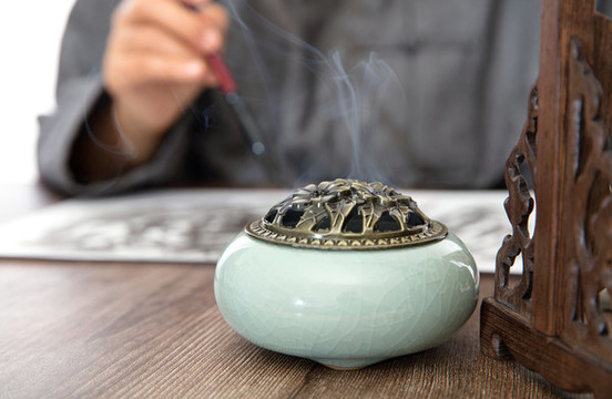 冒煙的香薰?fàn)t和書法創(chuàng)作的書法家