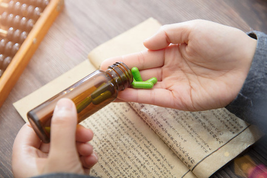 醫(yī)生倒出藥瓶里的膠囊