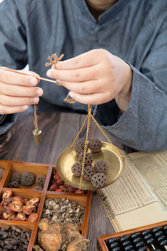 中醫(yī)藥師正在稱重中藥路路通