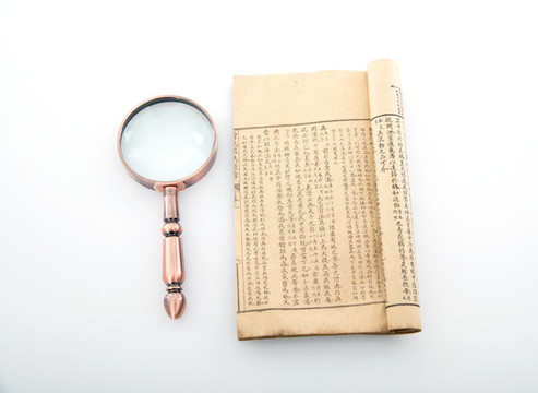 白背景上翻開的舊書和放大鏡