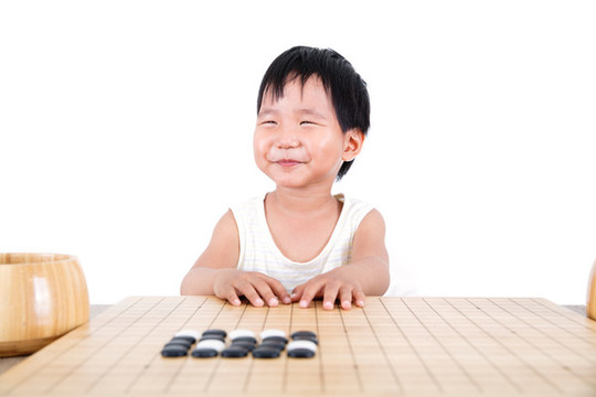 圍棋棋盤前滿面笑容的中國(guó)小女孩