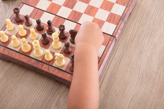 特寫小孩子的手正在下國(guó)際象棋