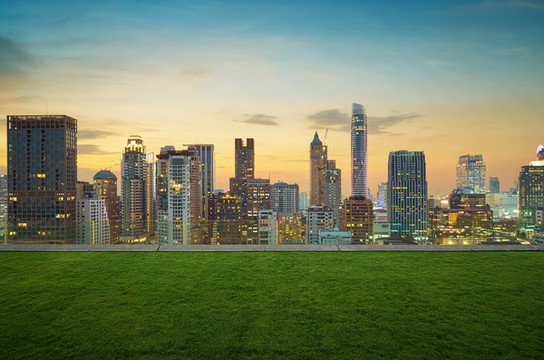 草綠地頂樓視角望遠(yuǎn)夕陽(yáng)下摩天大樓群照片