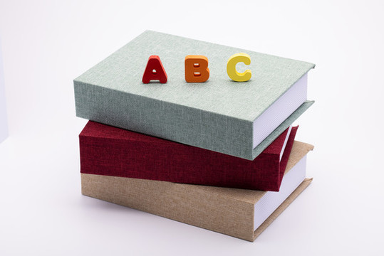 書本上放著大寫積木字母ABC