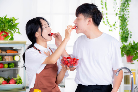 情侶在廚房甜蜜護(hù)喂西紅柿