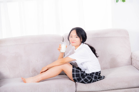 女士坐在沙發(fā)上喝牛奶