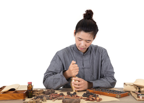 中國中醫(yī)學(xué)徒在使用銅藥臼搗藥