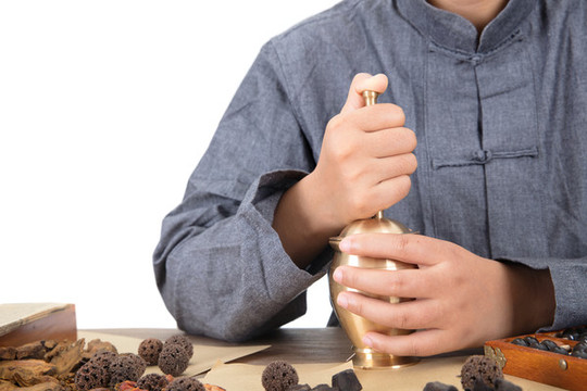 中醫(yī)大夫正用藥臼把中藥搗碎