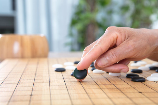 一枚黑色圍棋棋子預(yù)要落下