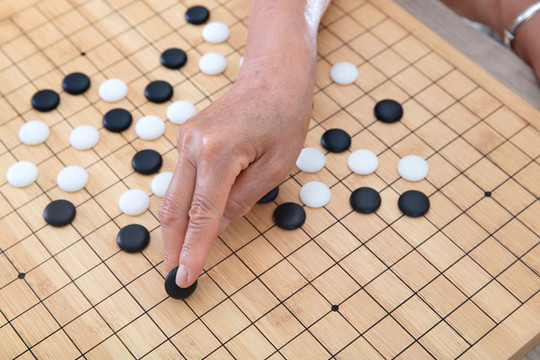 一枚黑色圍棋棋子預(yù)要落下