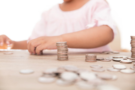 小孩子在擺放桌子上的硬幣
