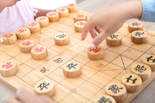 小女孩在和媽媽下中國象棋