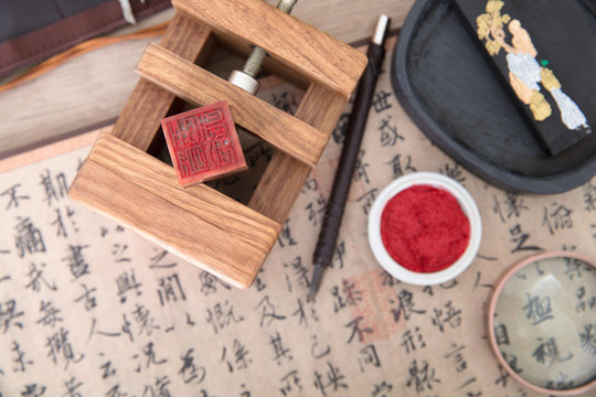 書桌上固定在刻床上的石質(zhì)印章