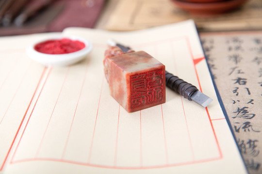 古書和上面放置著的印章及刻刀