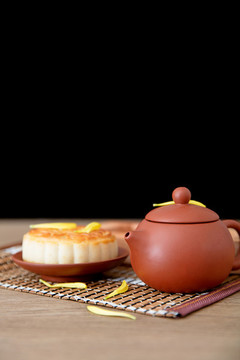 桌子上一壺茶和一塊月餅