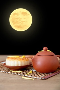 桌子上一壺茶和一塊月餅
