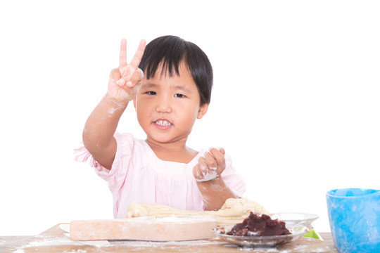 做月餅期間抬頭看鏡頭做手勢