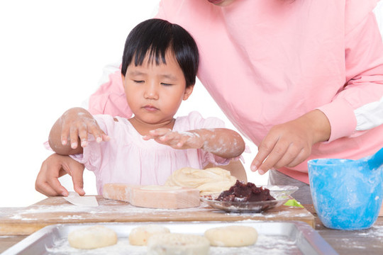 中國媽媽教自己的女兒學(xué)習(xí)做月餅