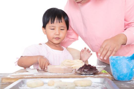 中國媽媽教自己的女兒學(xué)習(xí)做月餅