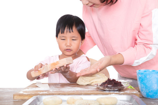 中國媽媽教自己的女兒學(xué)習(xí)做月餅