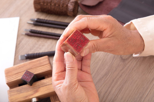 篆刻藝術(shù)家手拿石質(zhì)印章仔細(xì)觀察