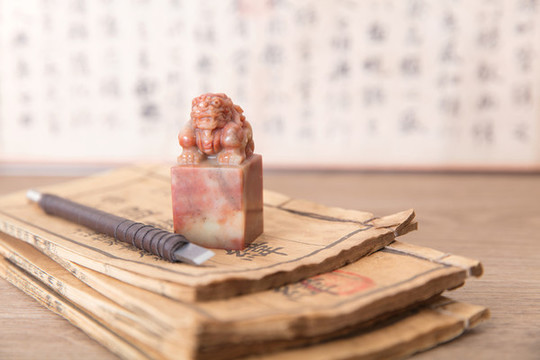 泛黃破舊古書上的印章和刻刀