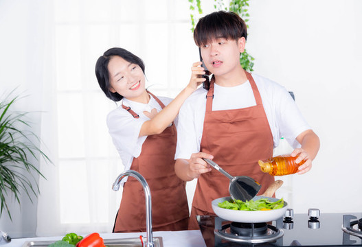 情侶在廚房趣味炒菜