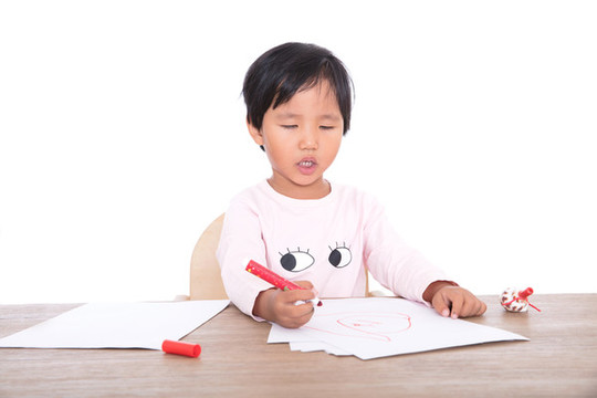 可愛的中國小女孩在認(rèn)真的畫畫