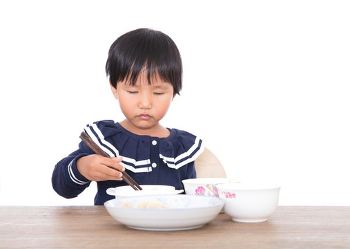 三歲黃皮膚女孩在獨自吃飯