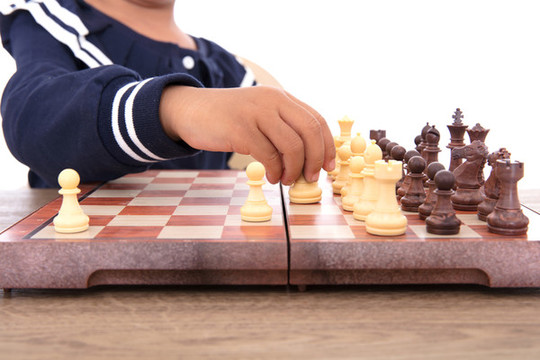 孩子下國際象棋棋盤上的特寫