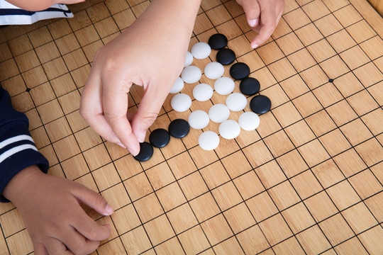 小孩子在棋盤上學習下圍棋